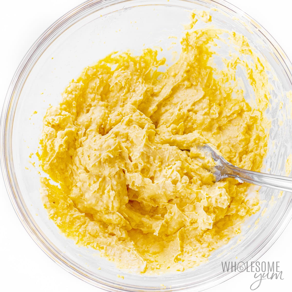 Egg yolks mashed and mixed with other ingredients in a bowl.