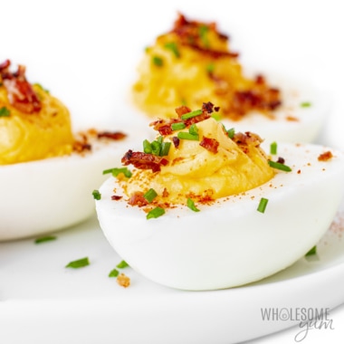 Deviled eggs with bacon assembled on a plate.