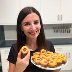 Maya holding a plate of healthy corn dogs.