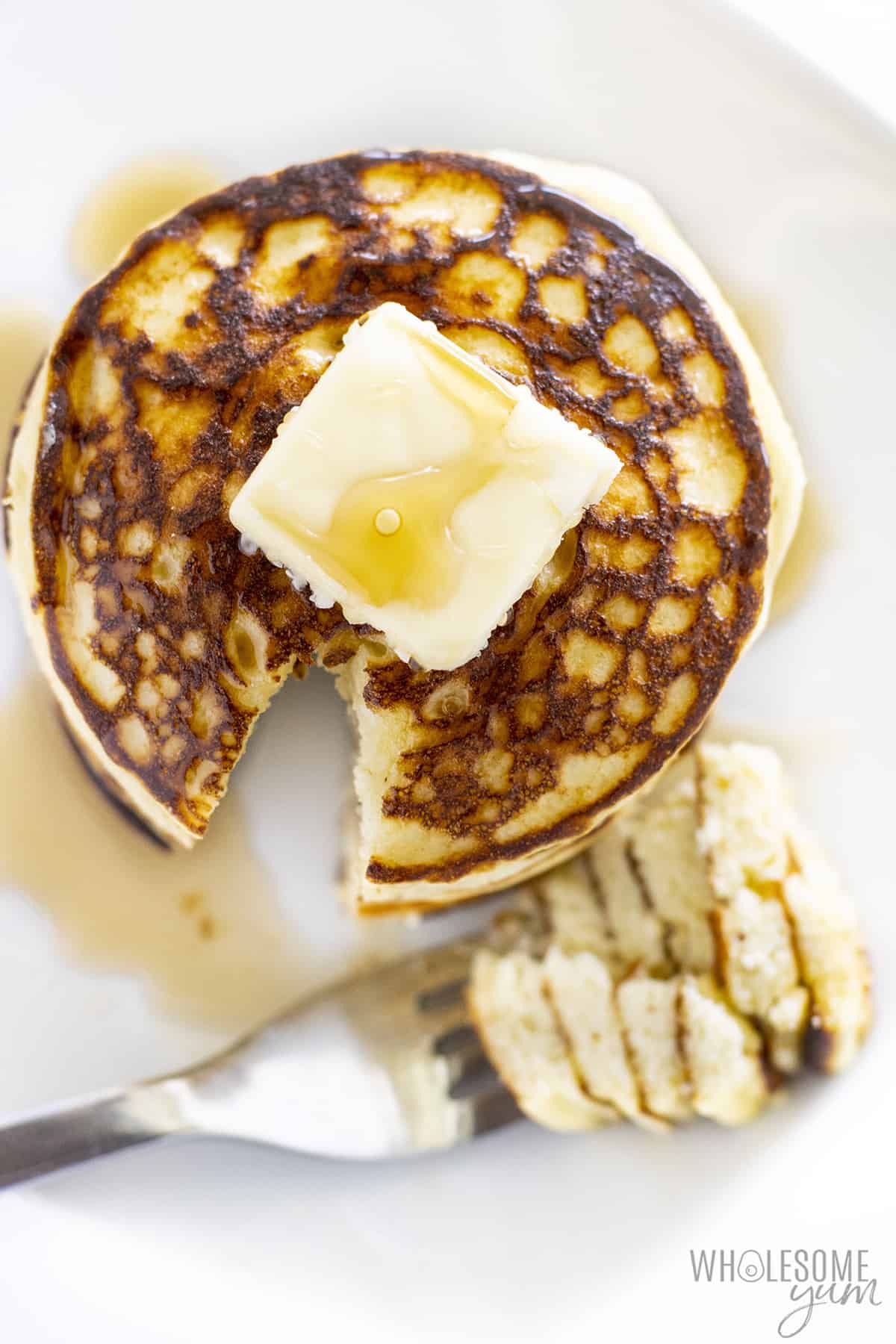 The coconut flour pancake recipe is shown overhead with a small piece of butter on it