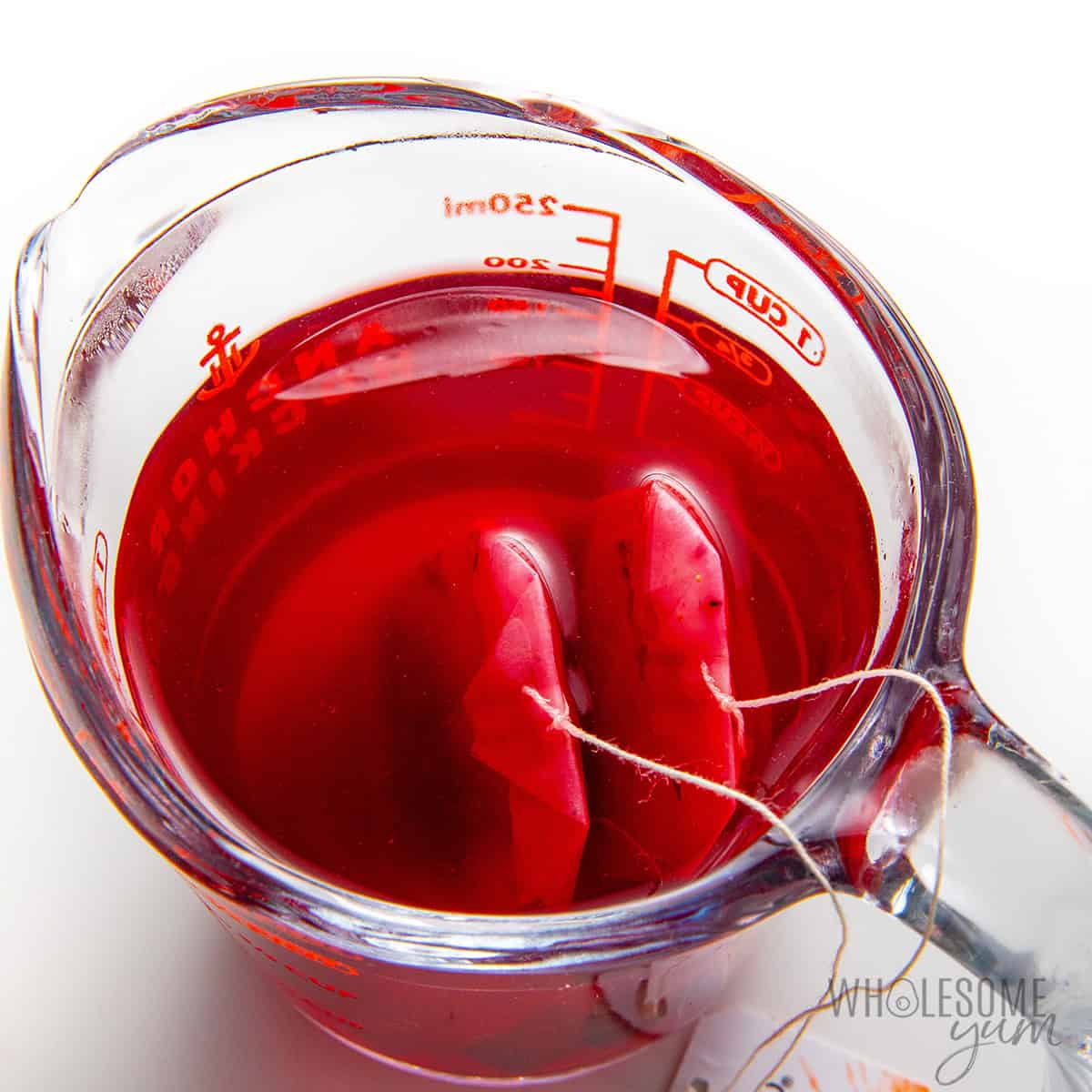 Passion tea steeping in a measuring cup.