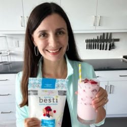 Maya holding a pink drink and a bag of Besti.