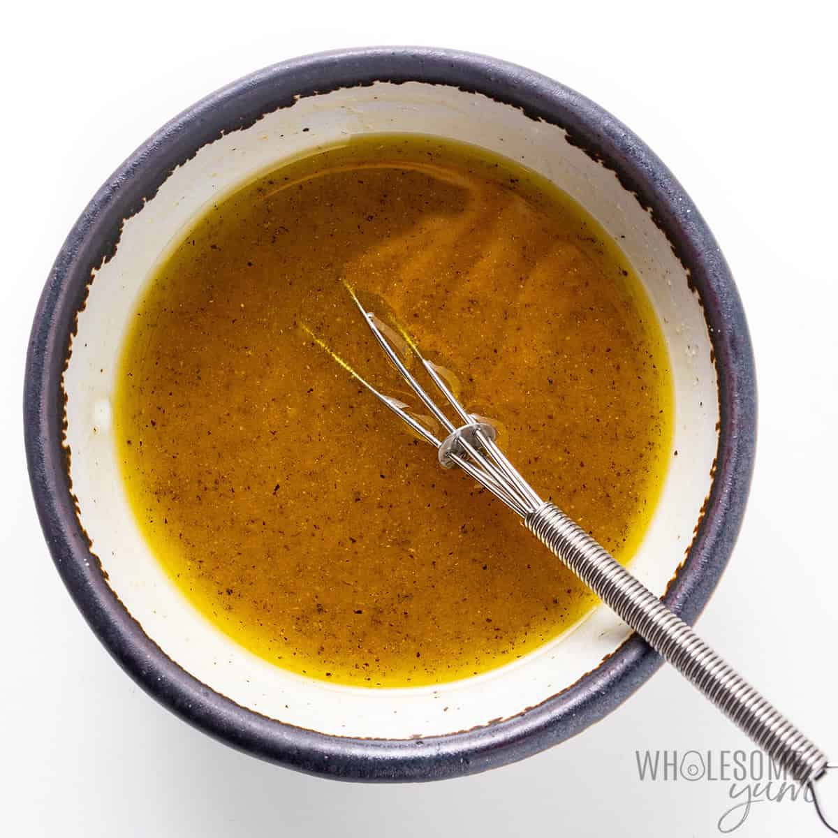 Whisking together salad dressing ingredients.