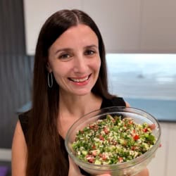 Maya holding a bowl of cauliflower tabbouleh.
