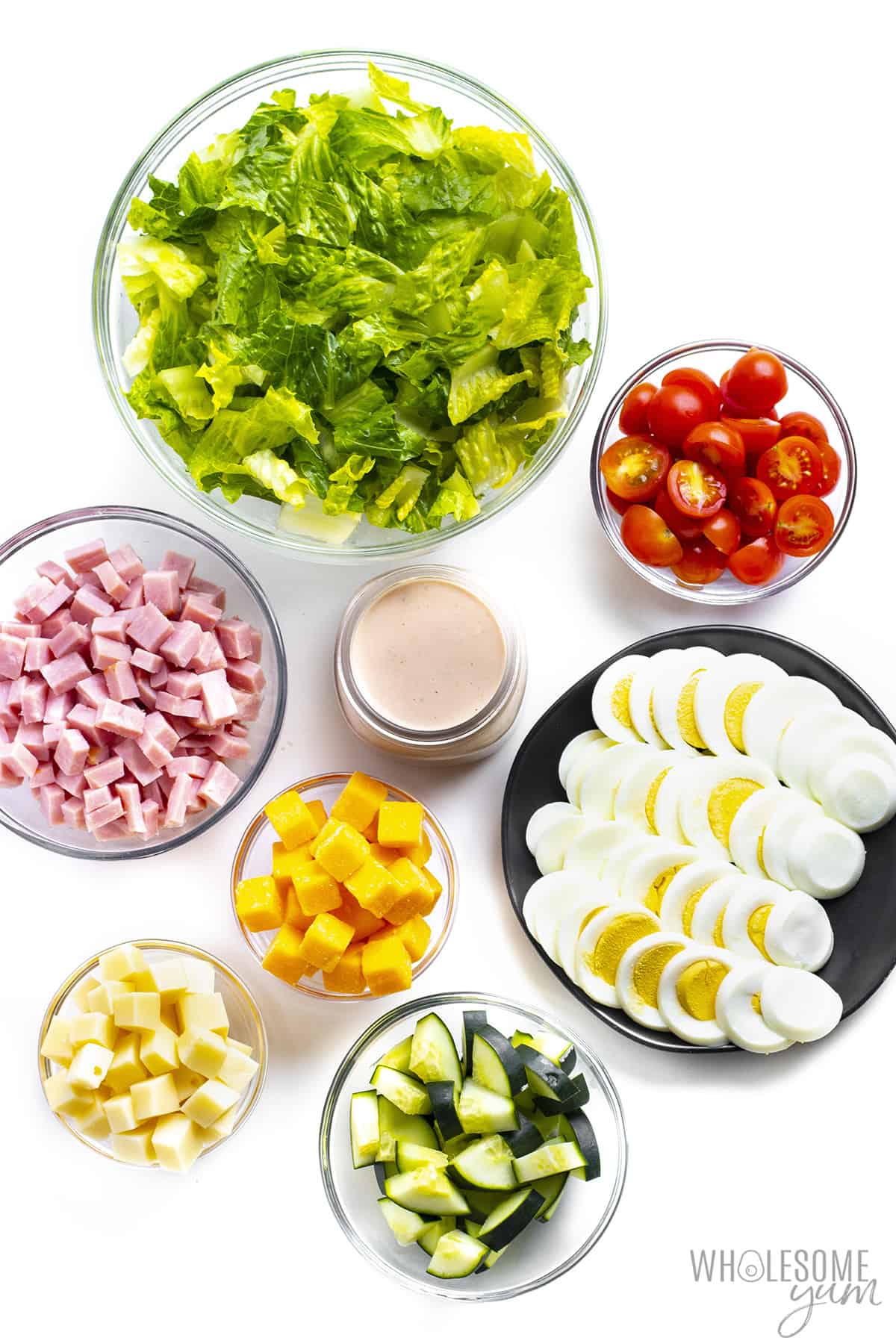 Chef salad ingredients in bowls.