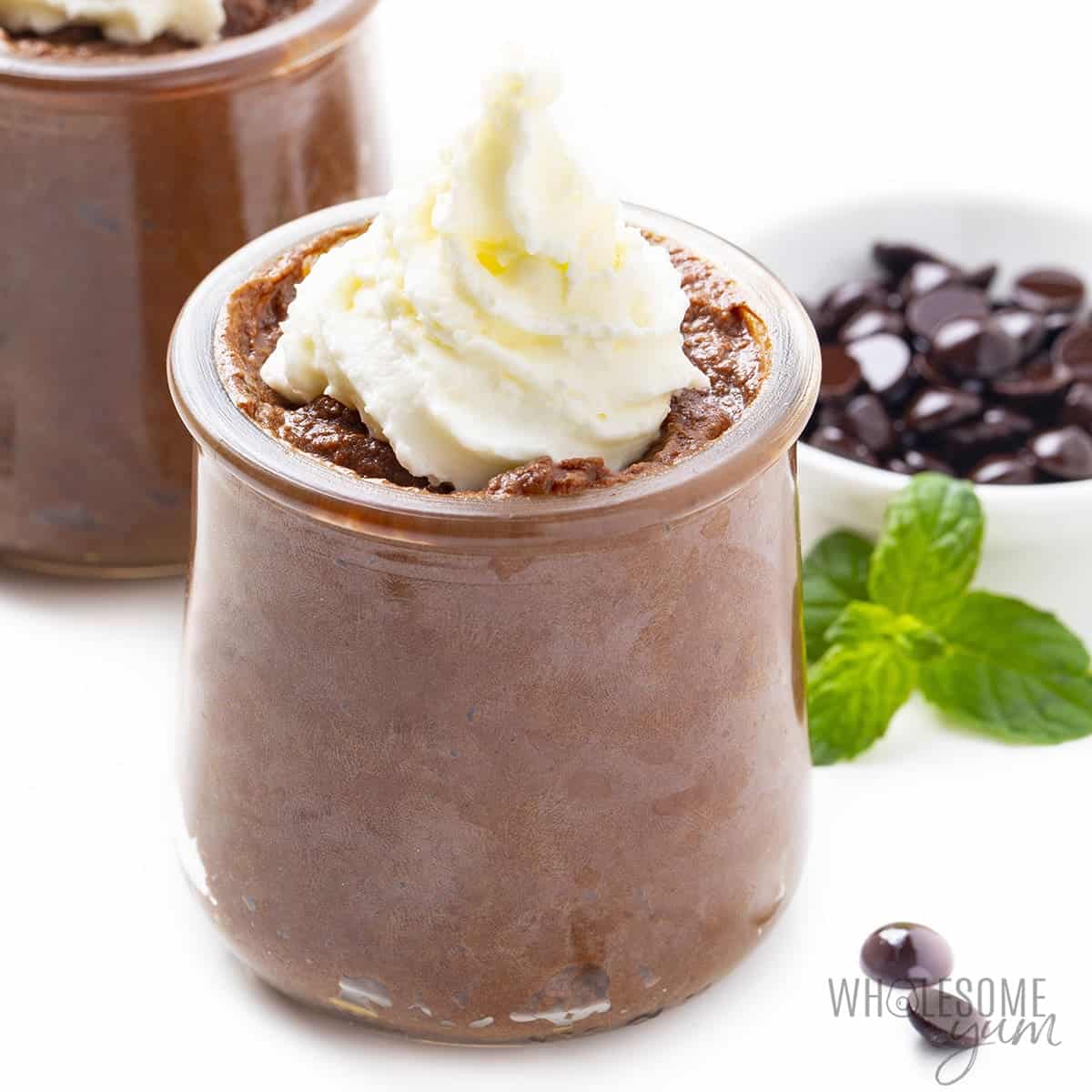 Keto chocolate mousse recipe in small jars with whipped cream.