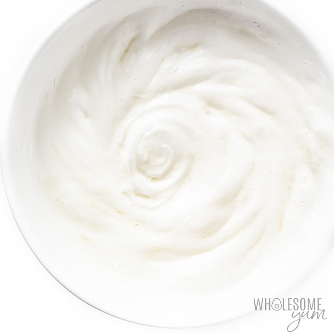 Soft peaks of egg whites in a bowl, tripled in volume