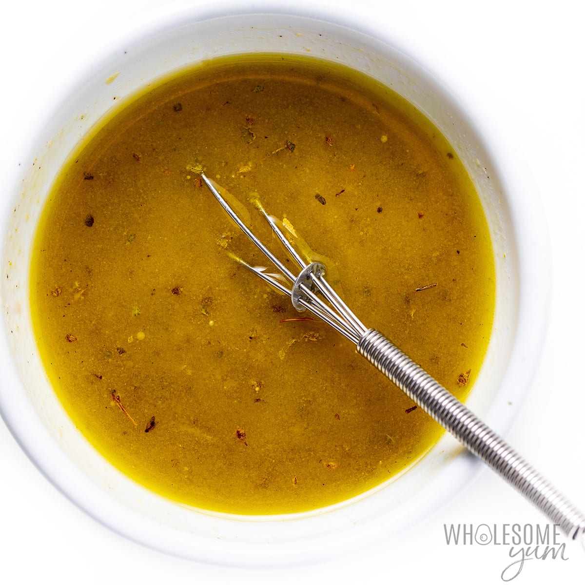 Greek salad dressing recipe whisked in a bowl.