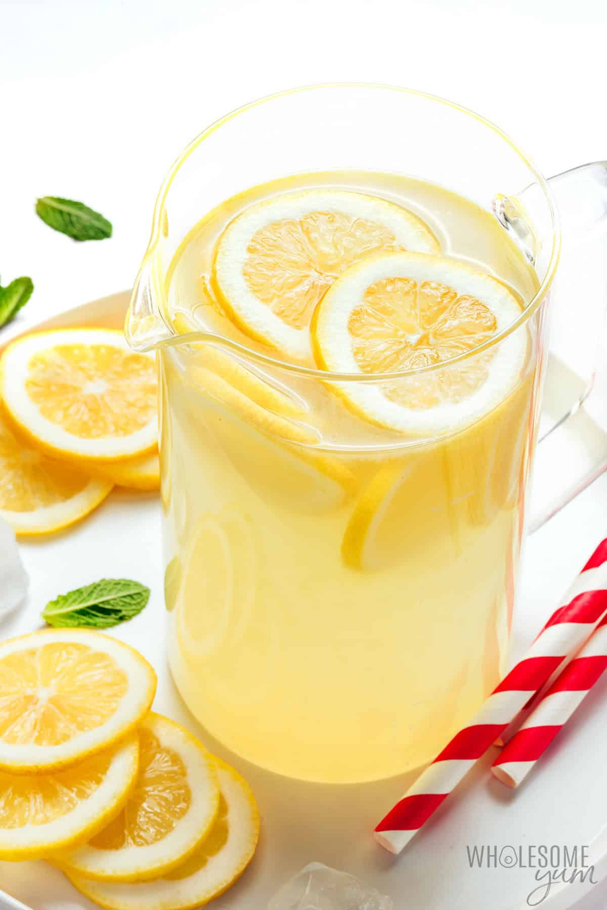 Freshly squeezed zero sugar lemonade in a pitcher with lemon slices.