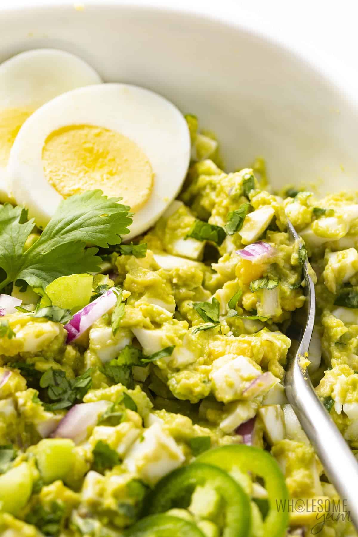 Avocado egg salad recipe close up with spoon.