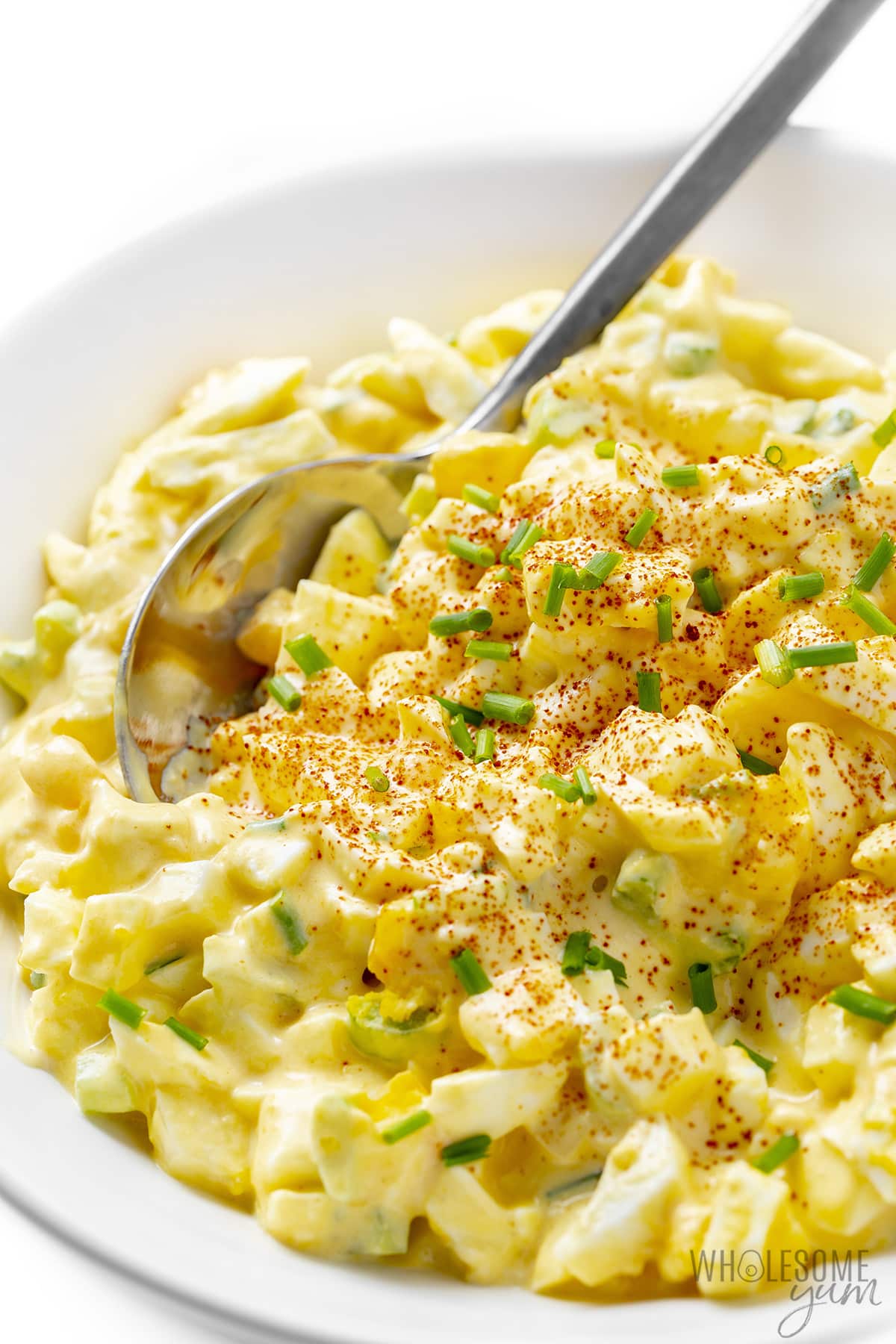 The best egg salad recipe in a bowl with a spoon.