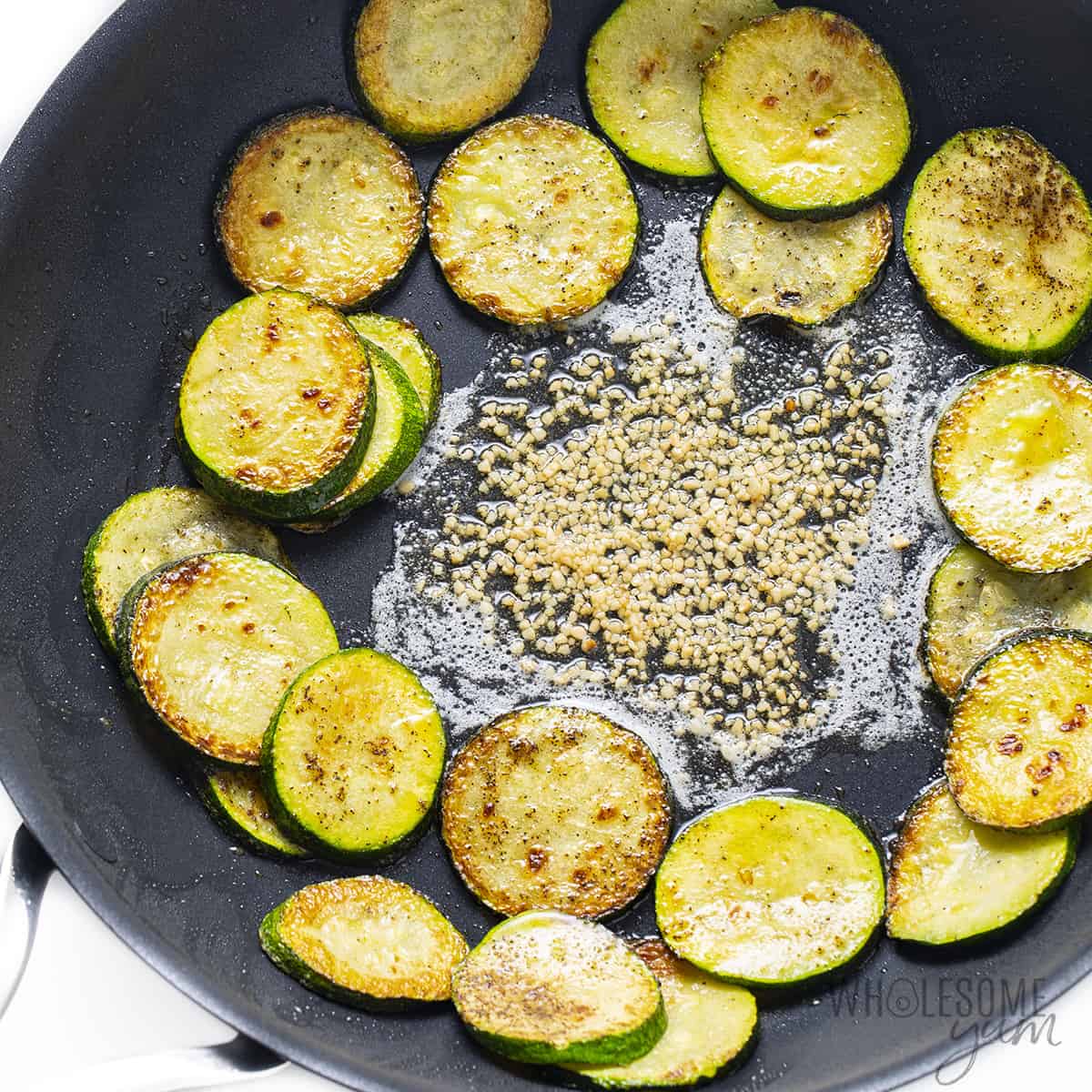 Sauteed zucchini with garlic and butter in a pan.