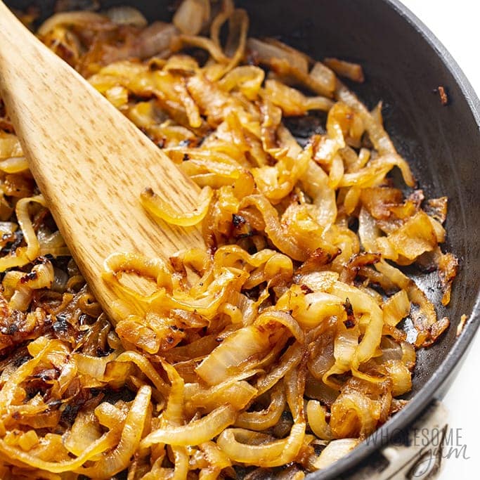 caramelized onions in a pan with a wooden spoon
