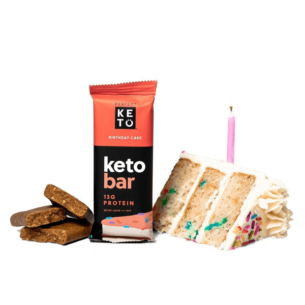 Perfect Keto birthday cake bar and packaging alongside slice of birthday cake