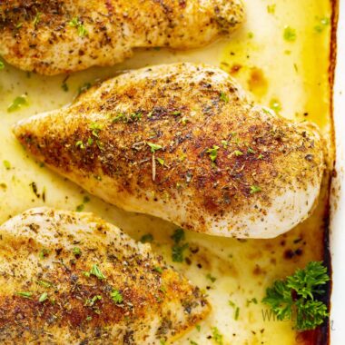 Healthy baked chicken breast in a baking dish.