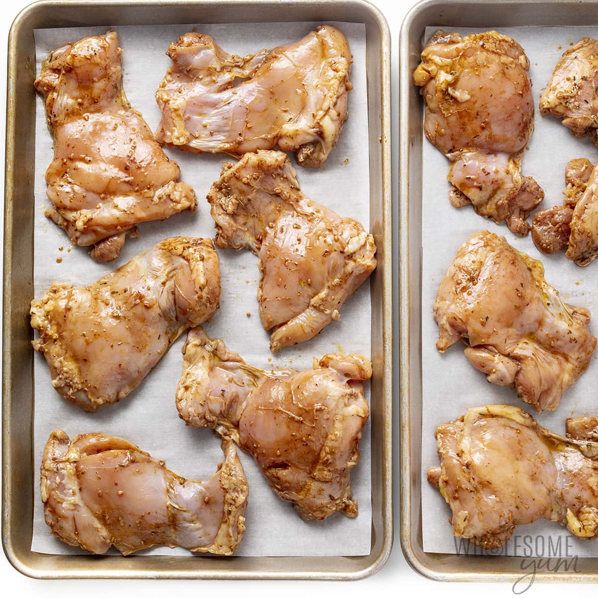 Marinated chicken arranged on a baking sheet.