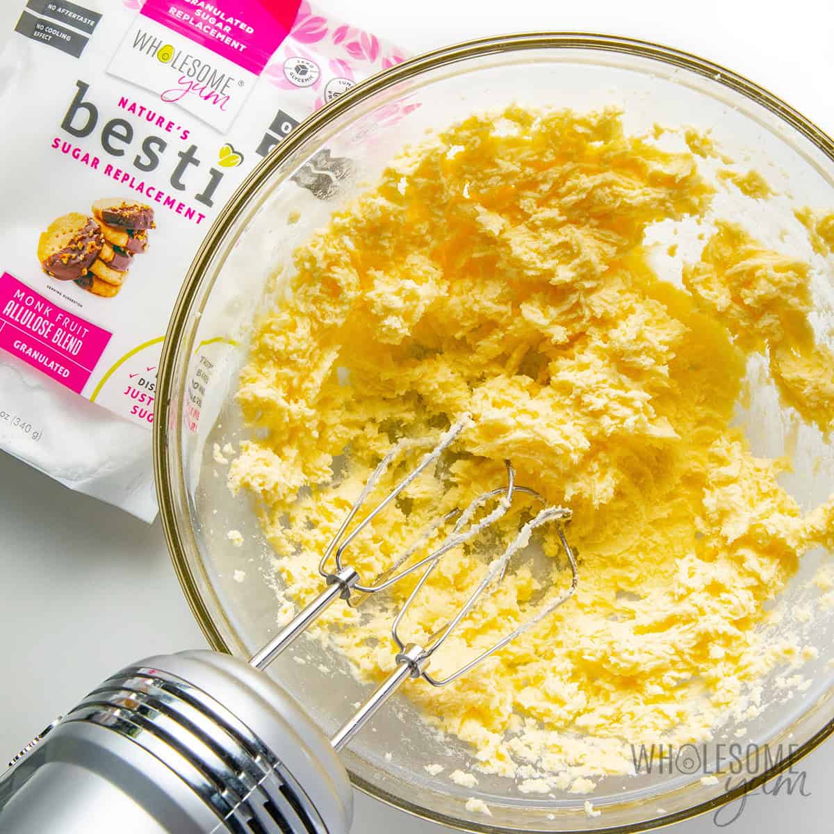 Creaming butter and Besti in a bowl with a hand mixer.