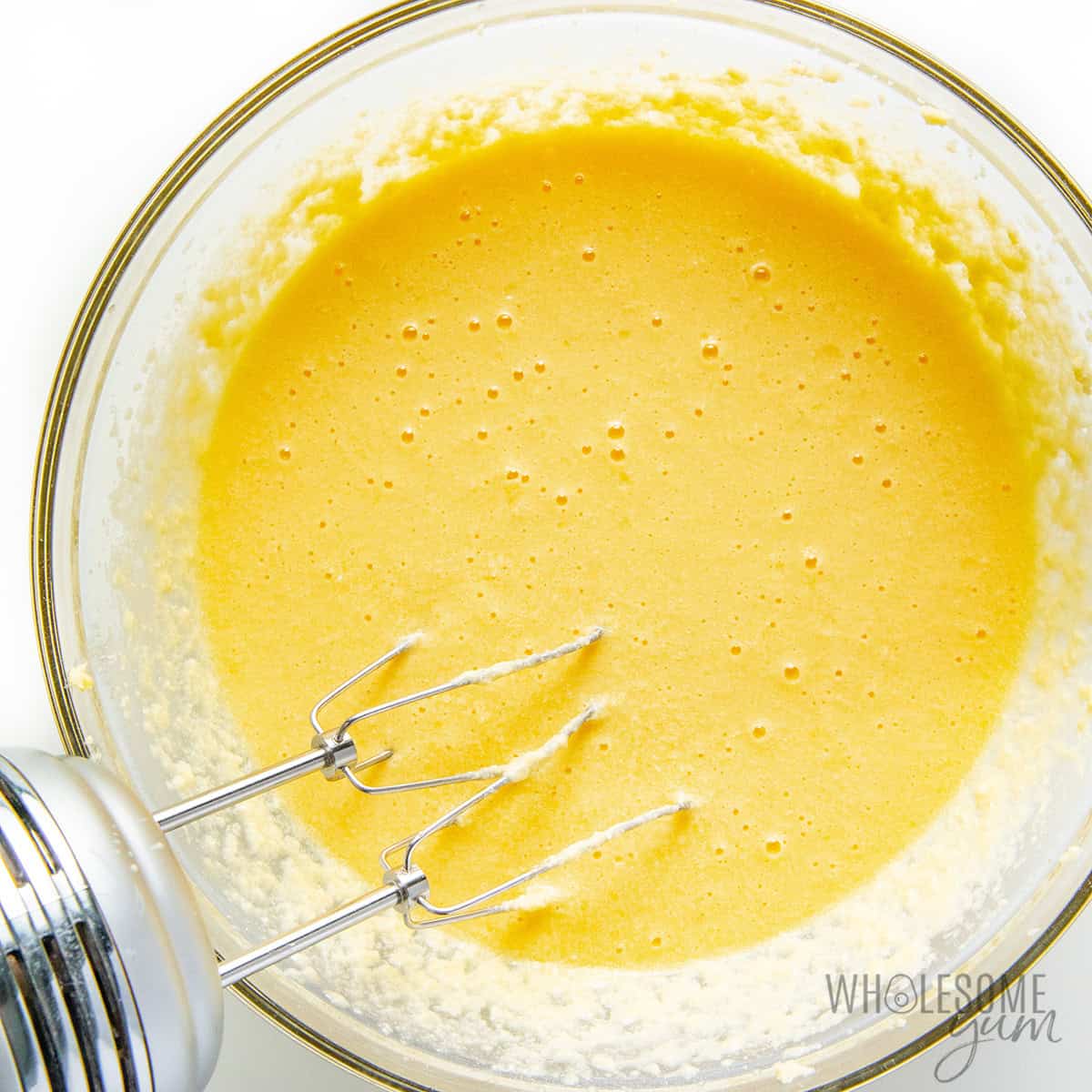 Blending wet ingredients into the creamed butter.