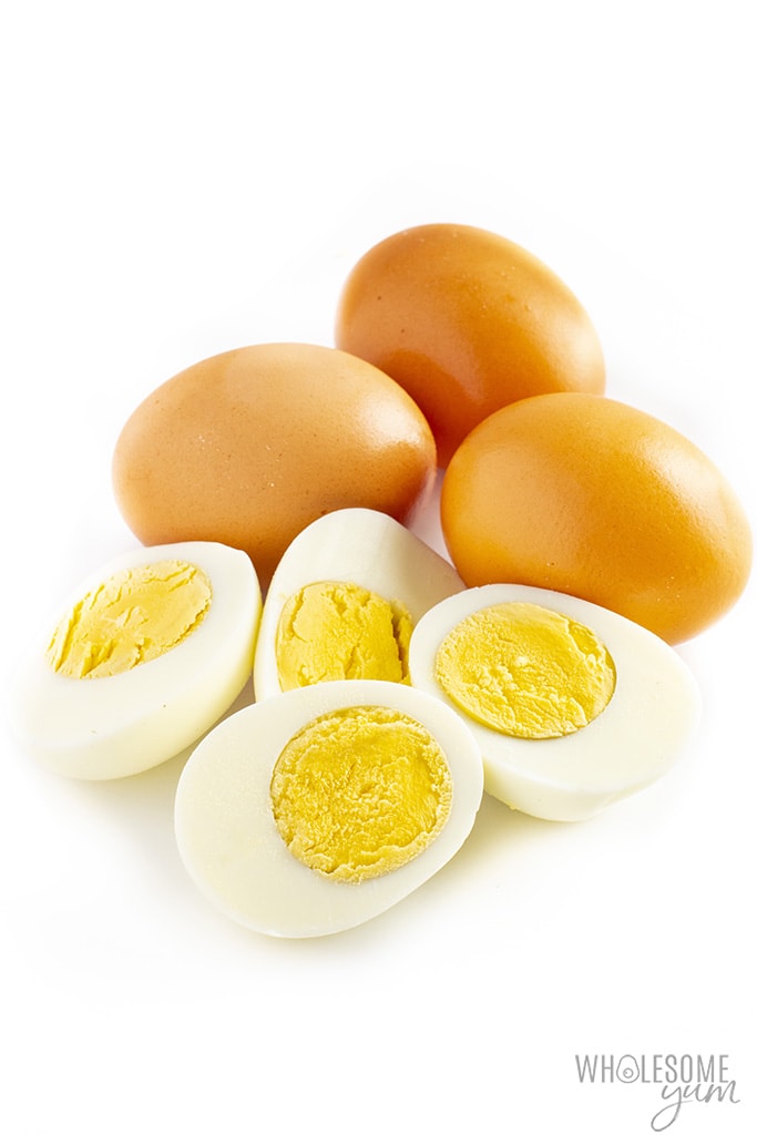 Are eggs keto? These boiled eggs sliced in half with brown unpeeled eggs in the back are low carb.