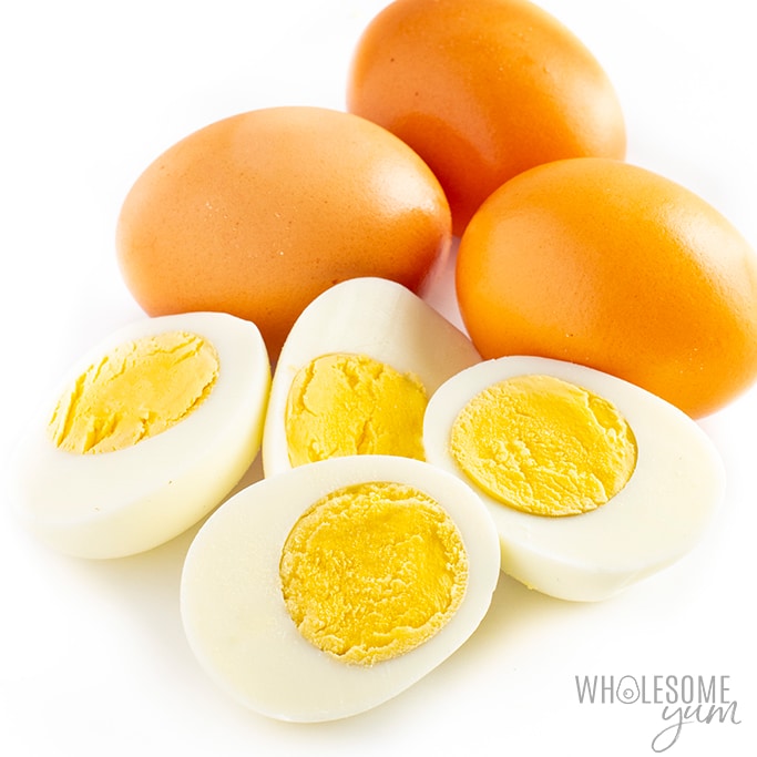 Are eggs keto? These boiled eggs sliced in half with brown unpeeled eggs in the back are keto.