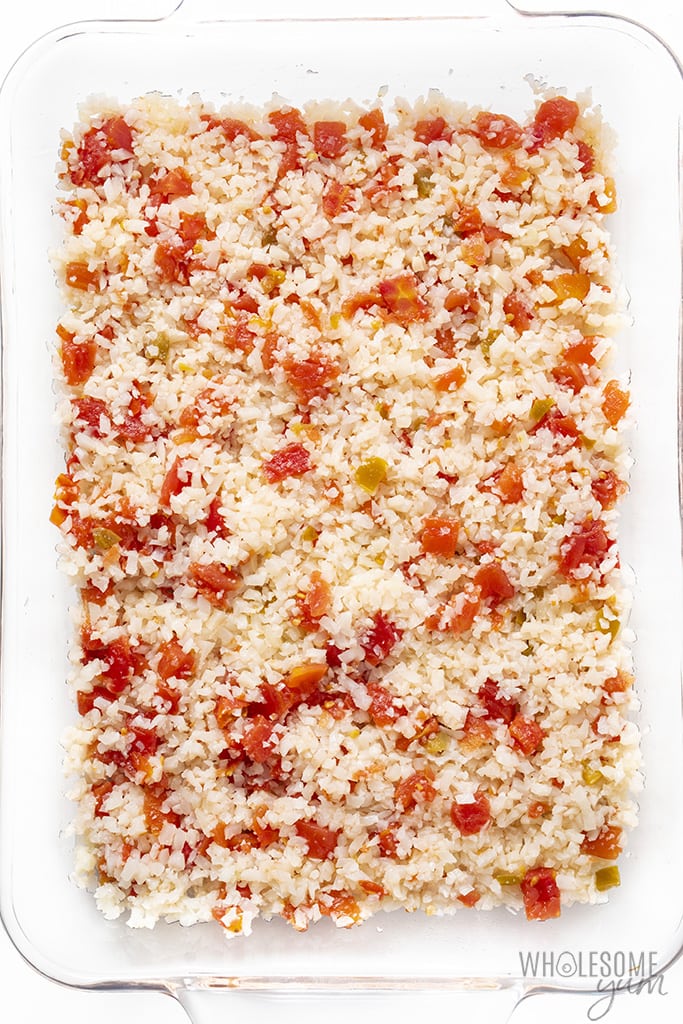 Overhead view of cauliflower rice and tomatoes in a casserole dish