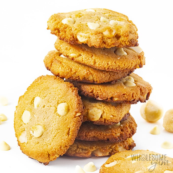 Stack of keto white chocolate macadamia nut cookies with white chocolate chips scattered