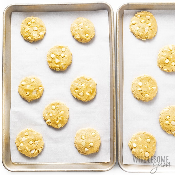 Overhead view of keto macadamia nut cookies on two sheet pans lined with parchment paper