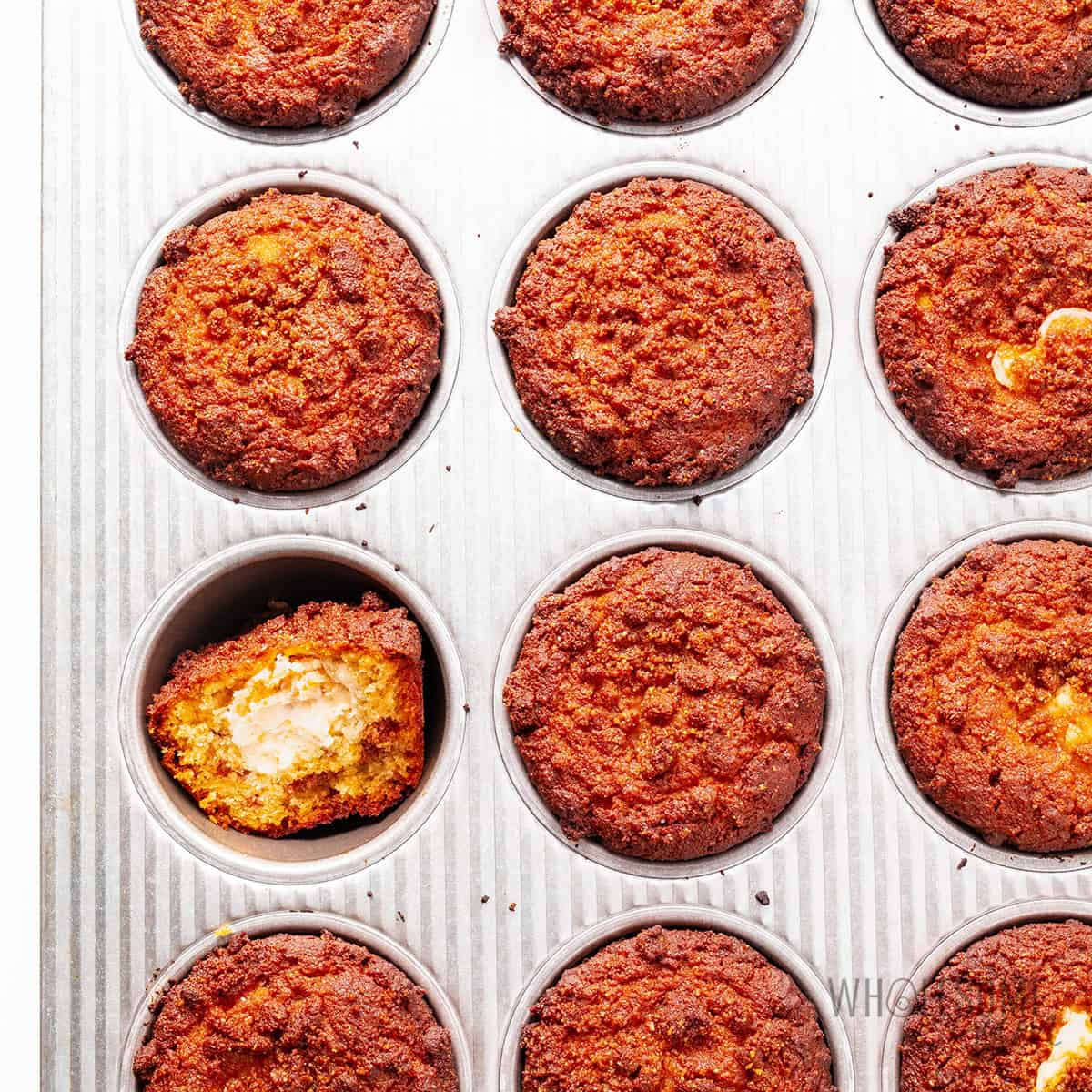 Baked coffee cake muffins in a muffin tin.