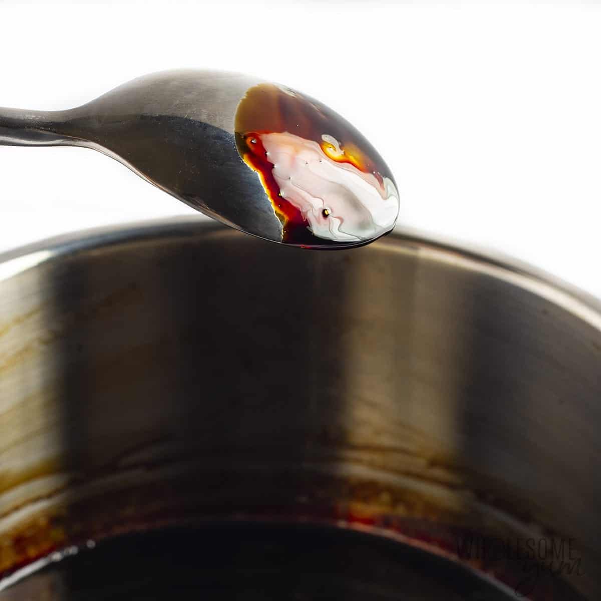 Balsamic reduction coating the back of a spoon.