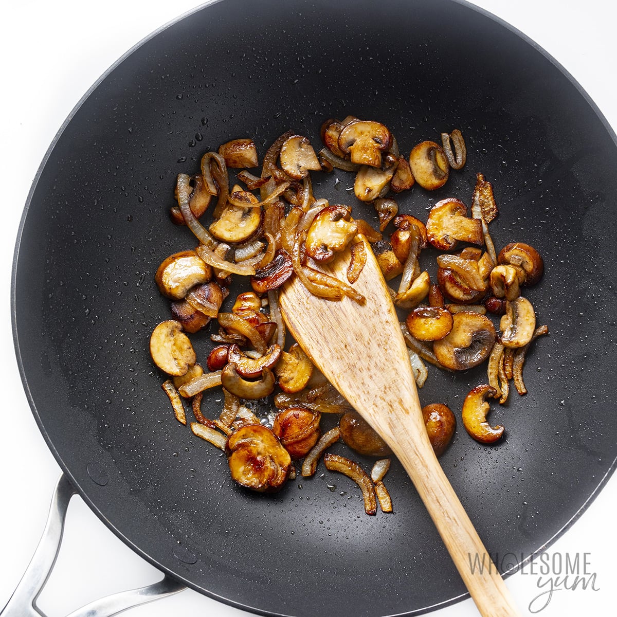 Mushrooms and onions sauteed in wok.