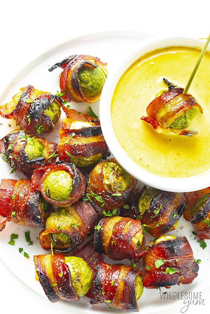 Platter full of brussels sprouts with bacon and dipping sauce
