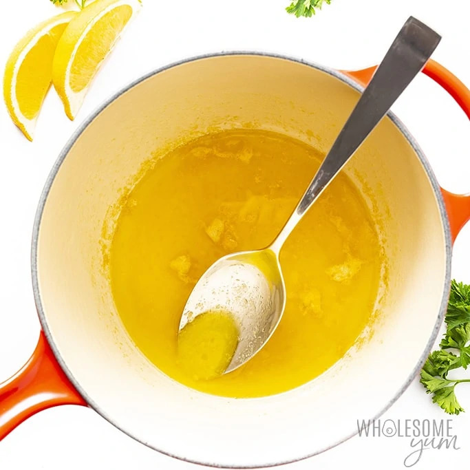 Lemon butter sauce for fish in a saucepan with a spoon