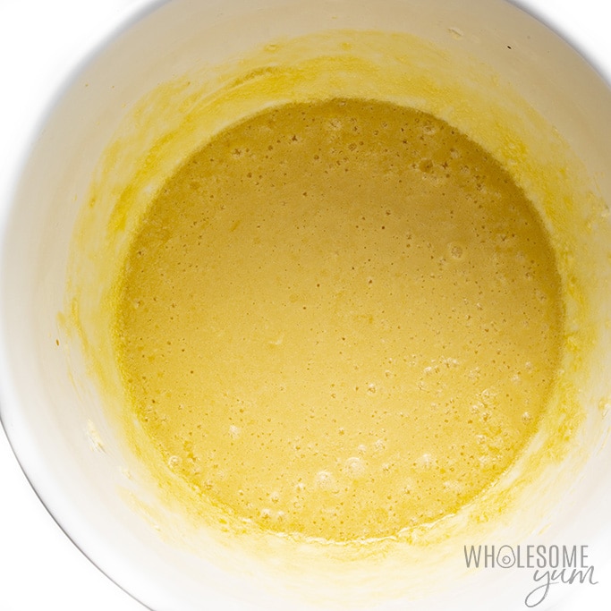 Eggs, cream, vanilla, and butter mixture in a bowl for almond flour cinnamon muffins