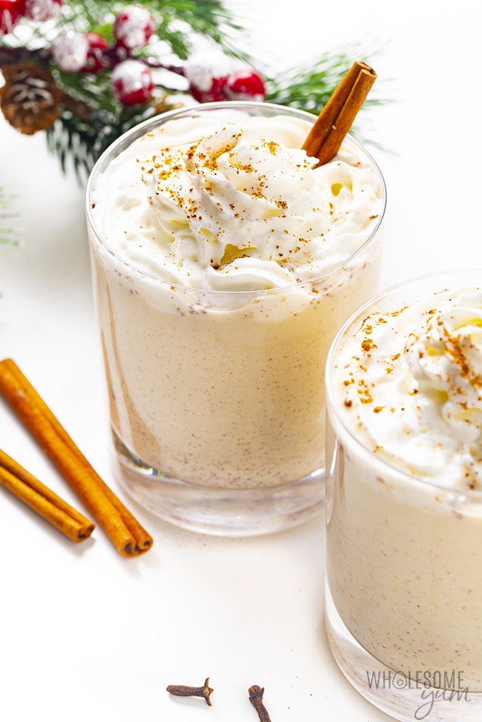 Two glasses of sugar-free eggnog with whipped cream and a cinnamon stick