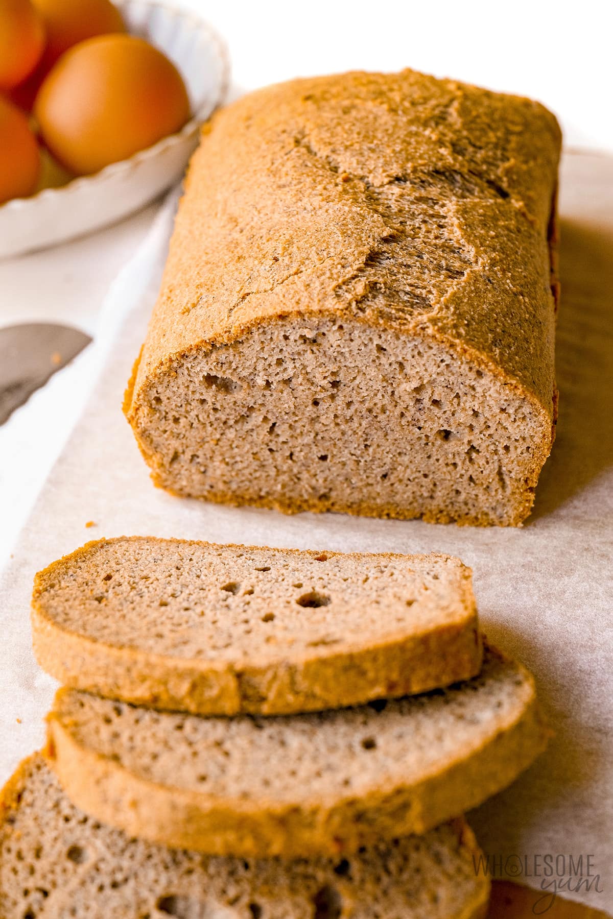 Slices of almond flour bread coming off a whole loaf.
