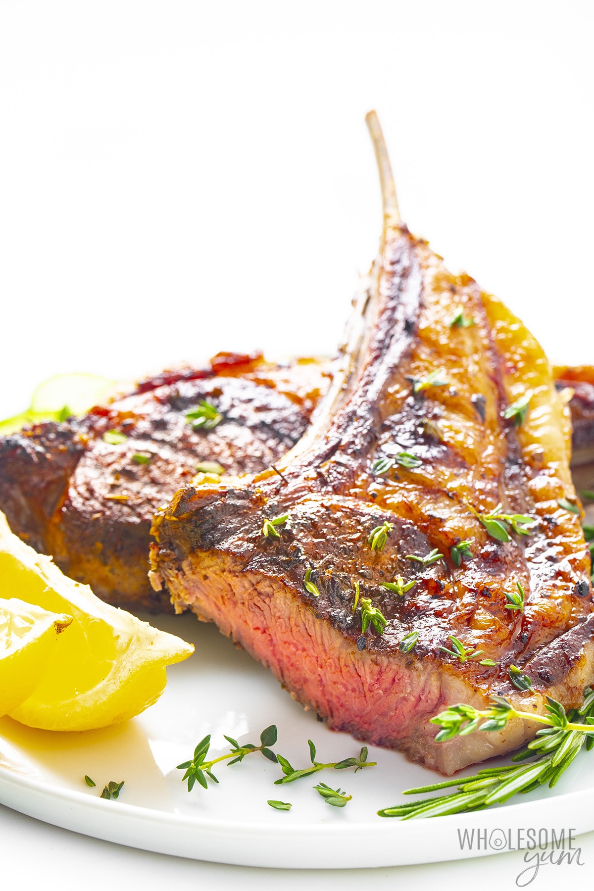 Oven lamb chops on a plate with a slice cut off to show the inside.