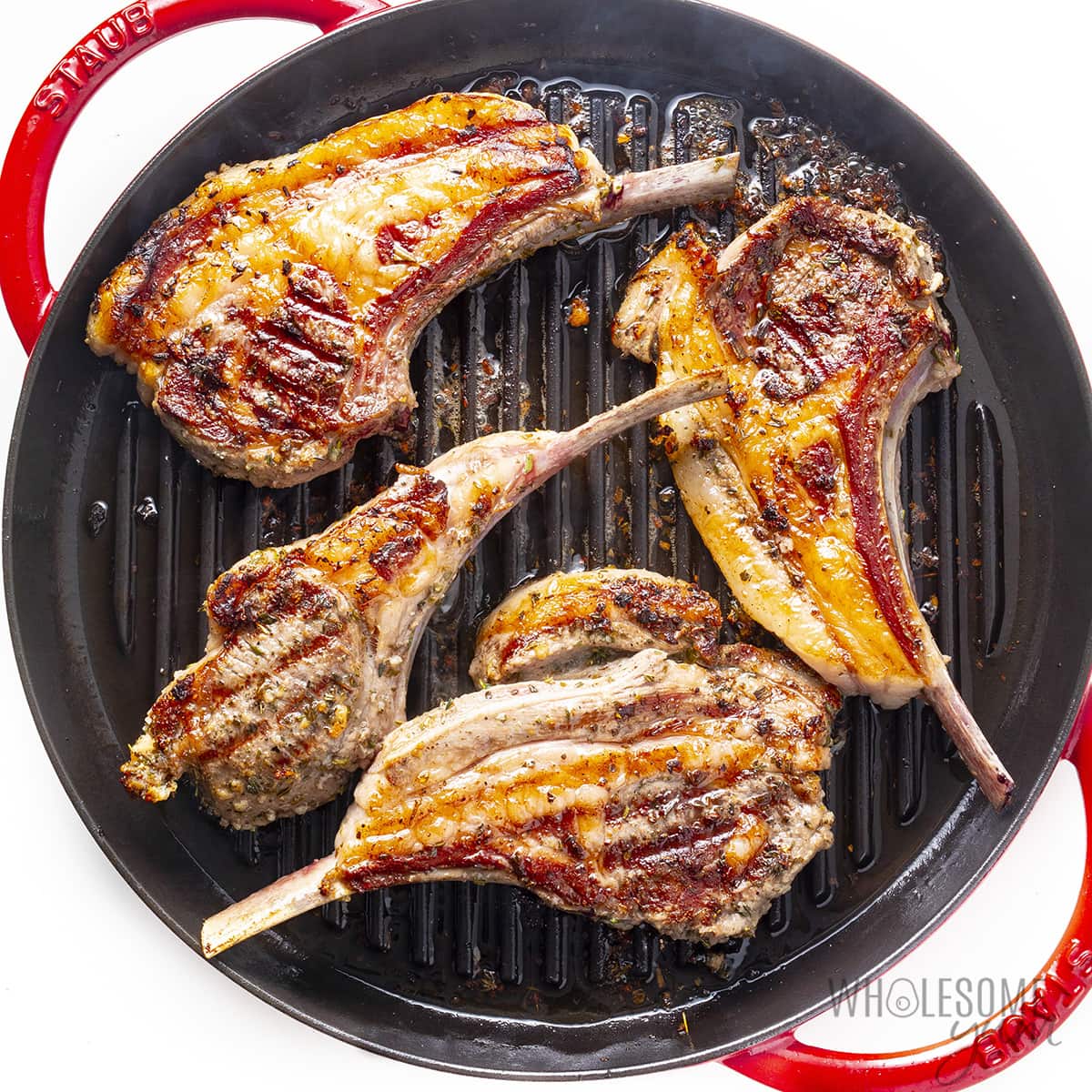 Lamb chops seared on a cast iron skillet.