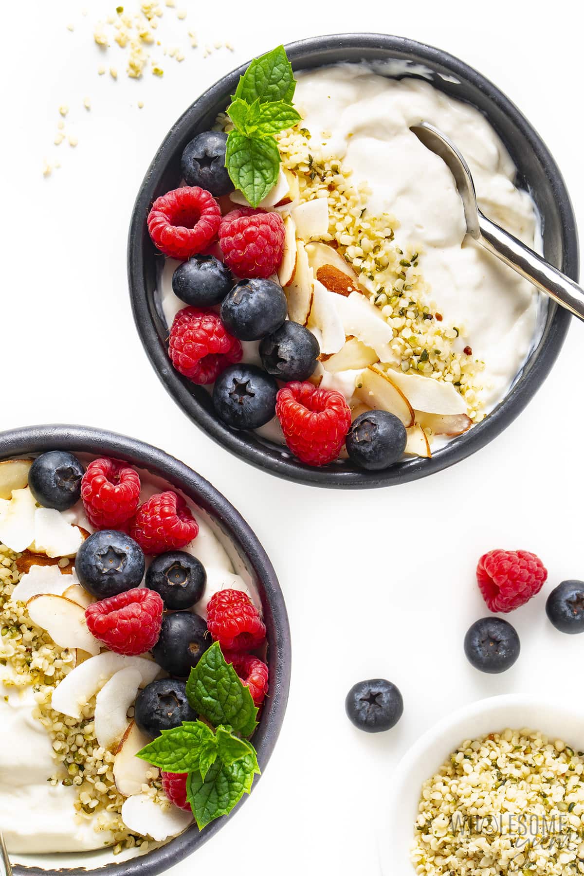 Two bowls of low carb yogurt with toppings.