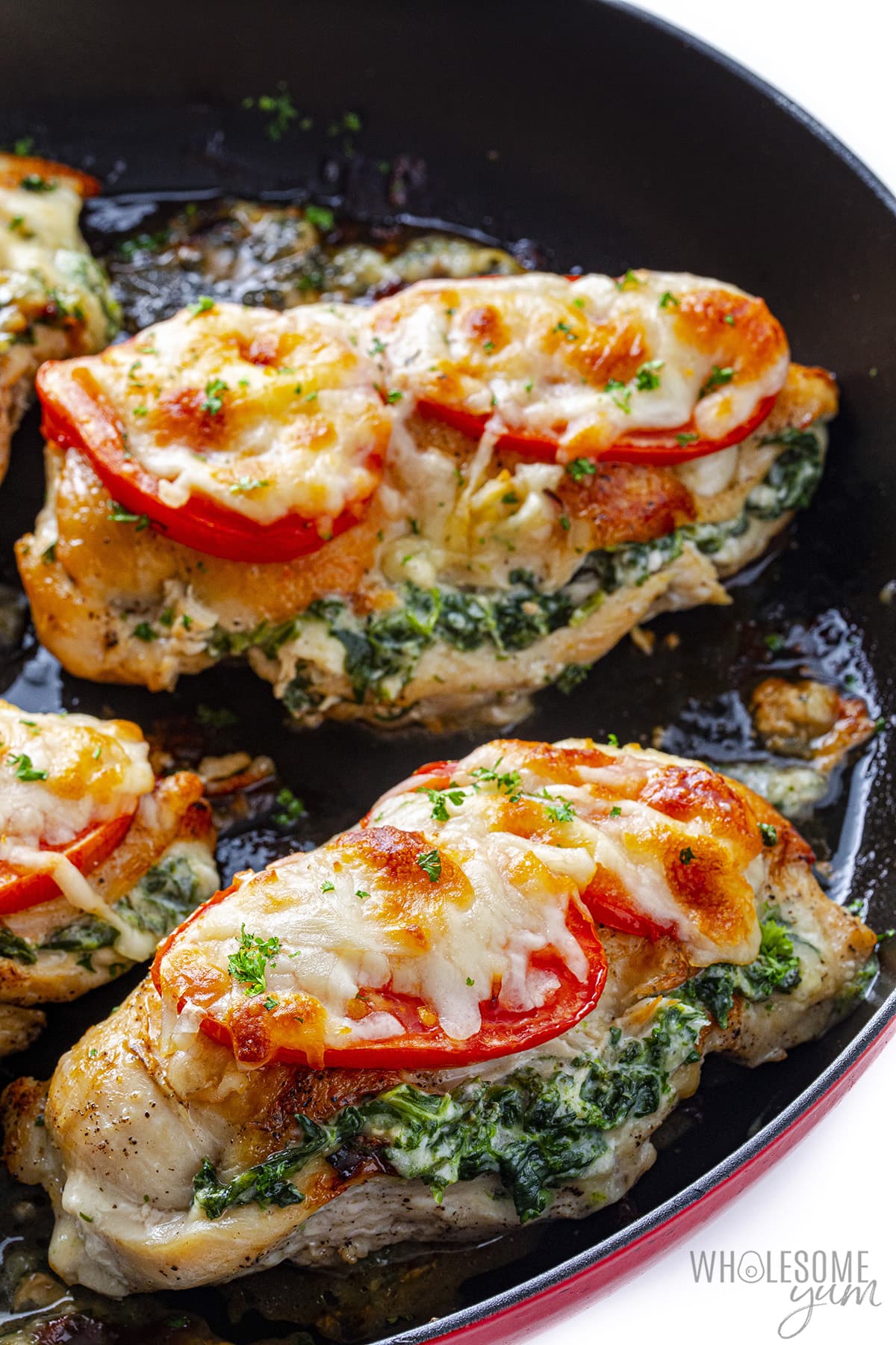 Spinach stuffed chicken breast in a skillet.