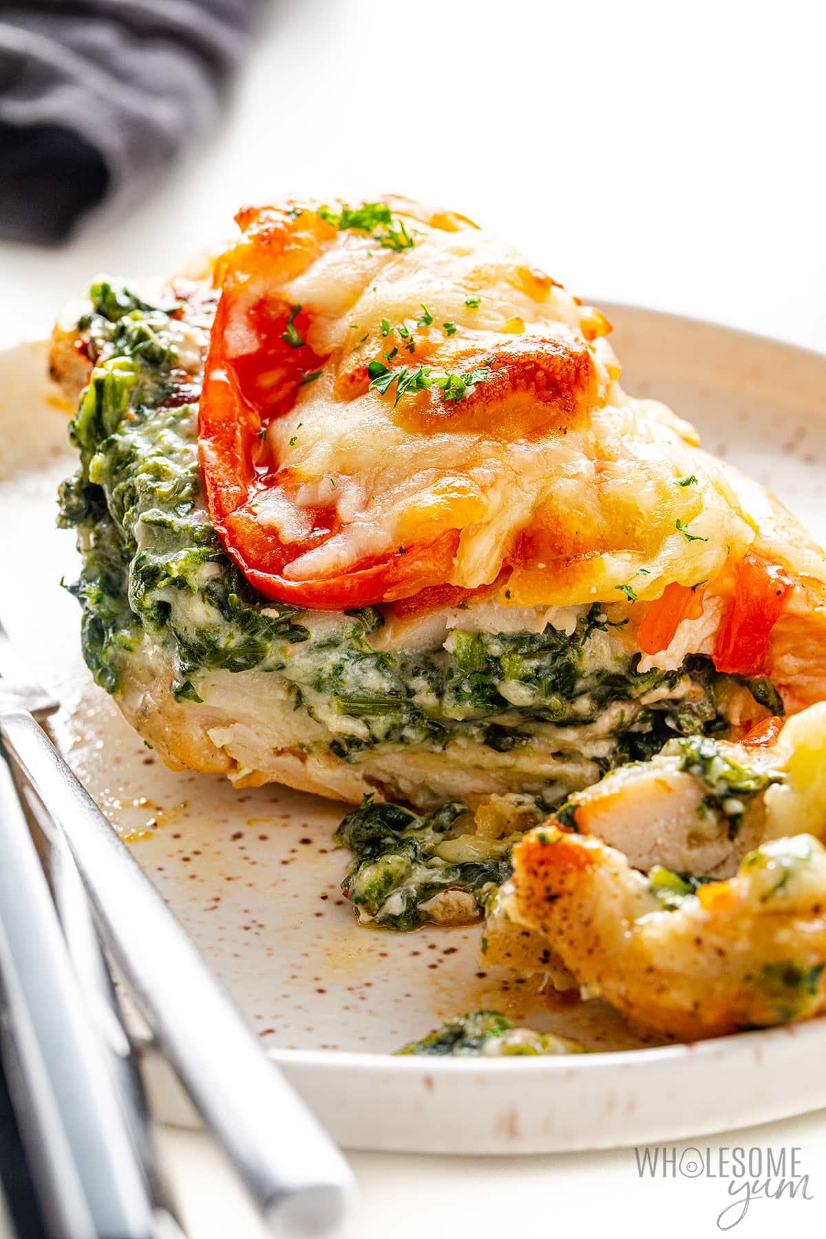 Spinach stuffed chicken sliced on a plate.