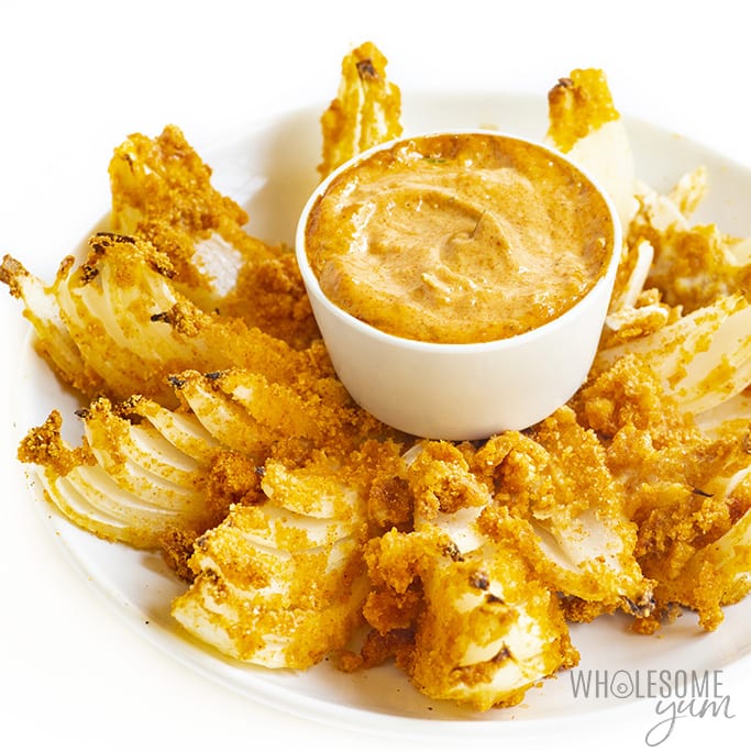 Keto blooming onion with bowl of dipping sauce in the middle