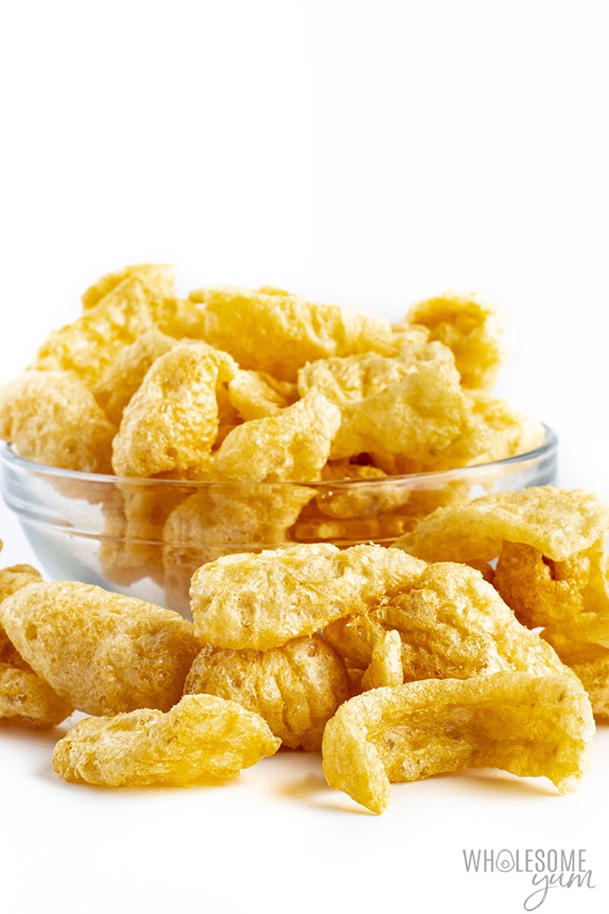 Are pork rinds keto? These pork rinds spilling out of a glass bowl are keto friendly.