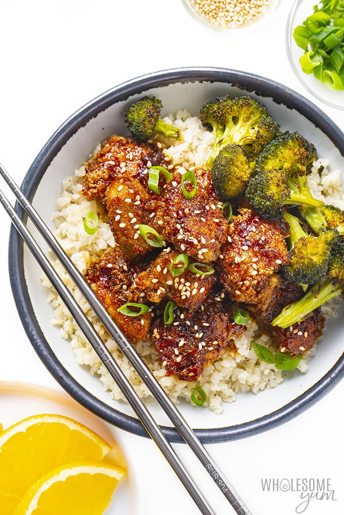 Low carb orange chicken in a bowl with cauliflower rice and broccoli
