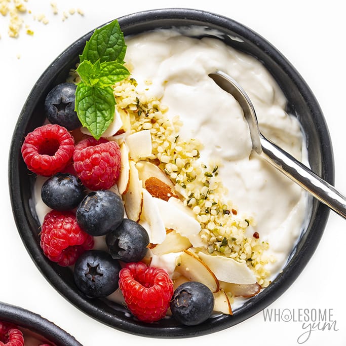 Bowl with keto yogurt topped with berries and hemp hearts