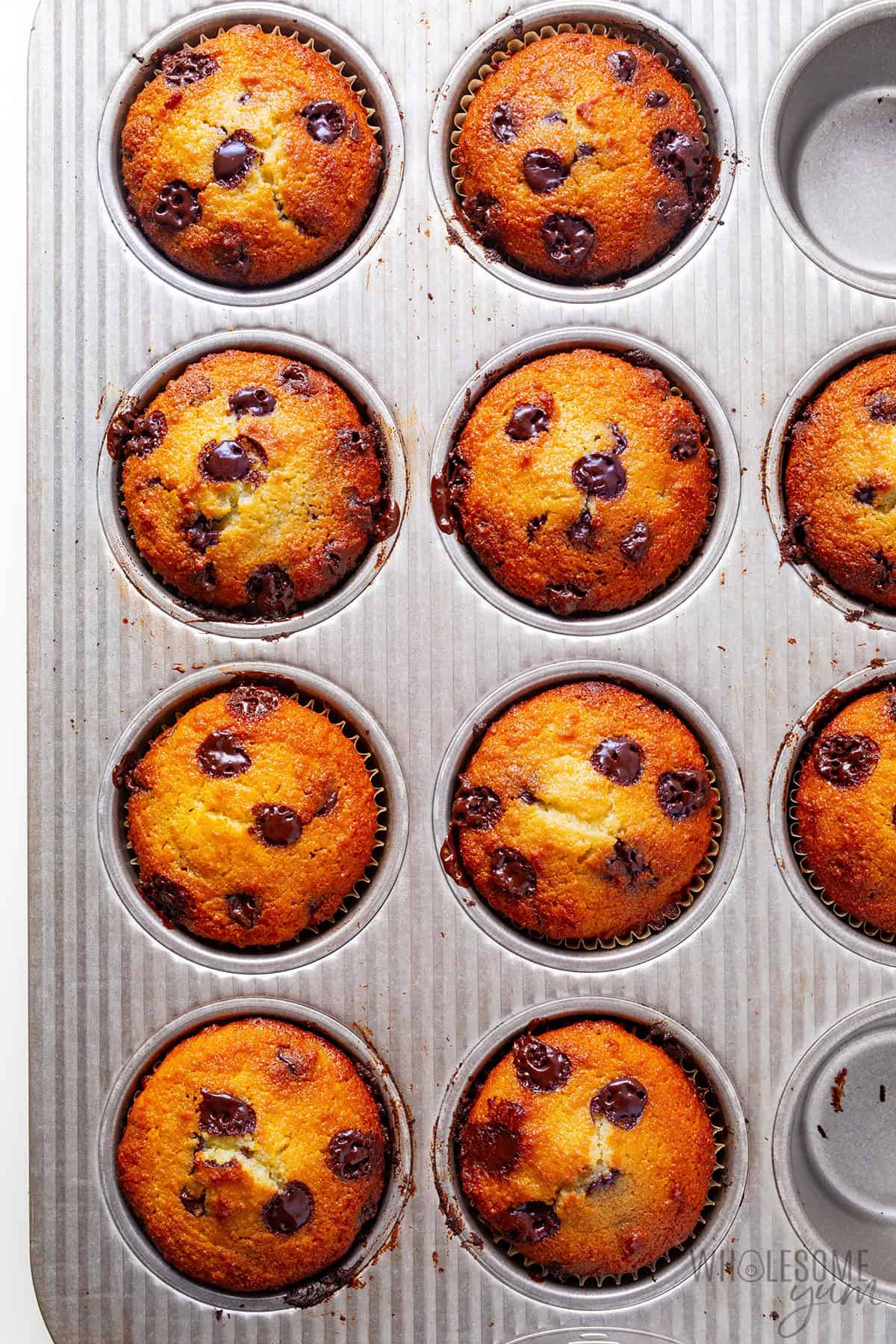 Moist, fluffy almond flour chocolate chip muffins in a baking pan.