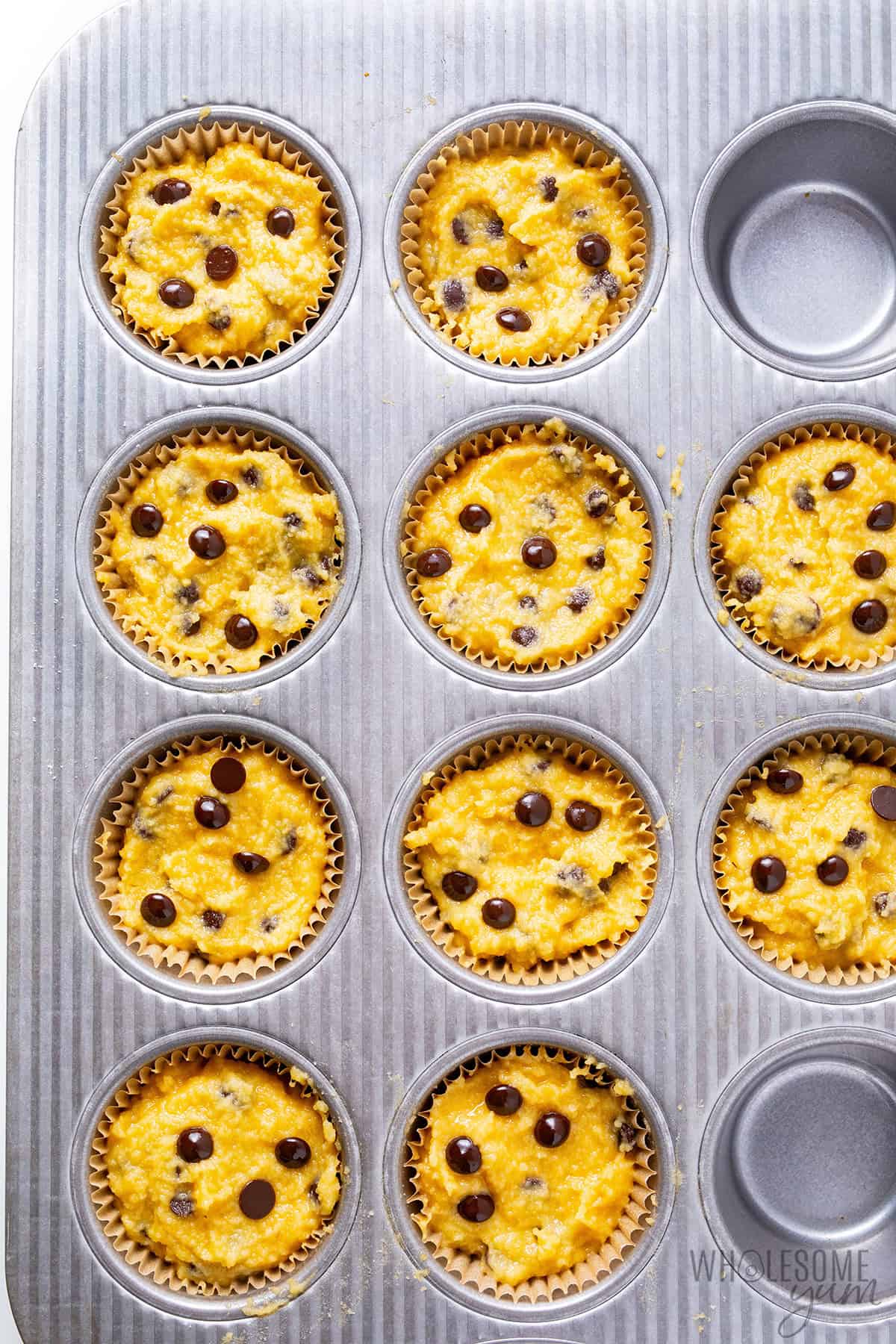Almond flour chocolate chip muffin batter portioned into a lined muffin tin.