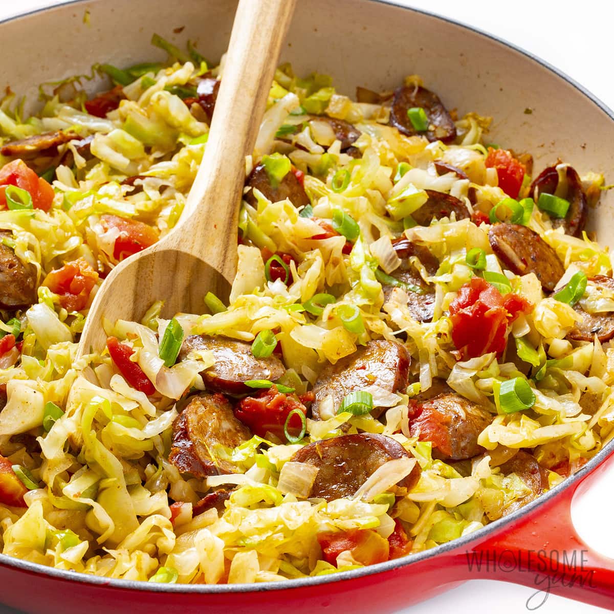 Cabbage and sausage in a pan.