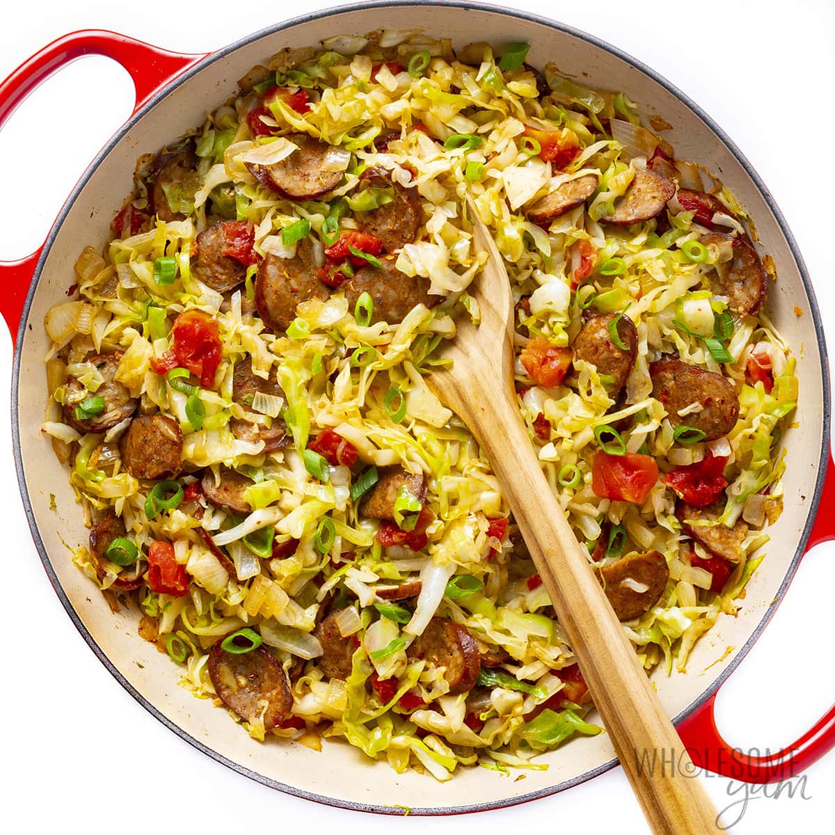 Cooked sausage and cabbage in a pan.