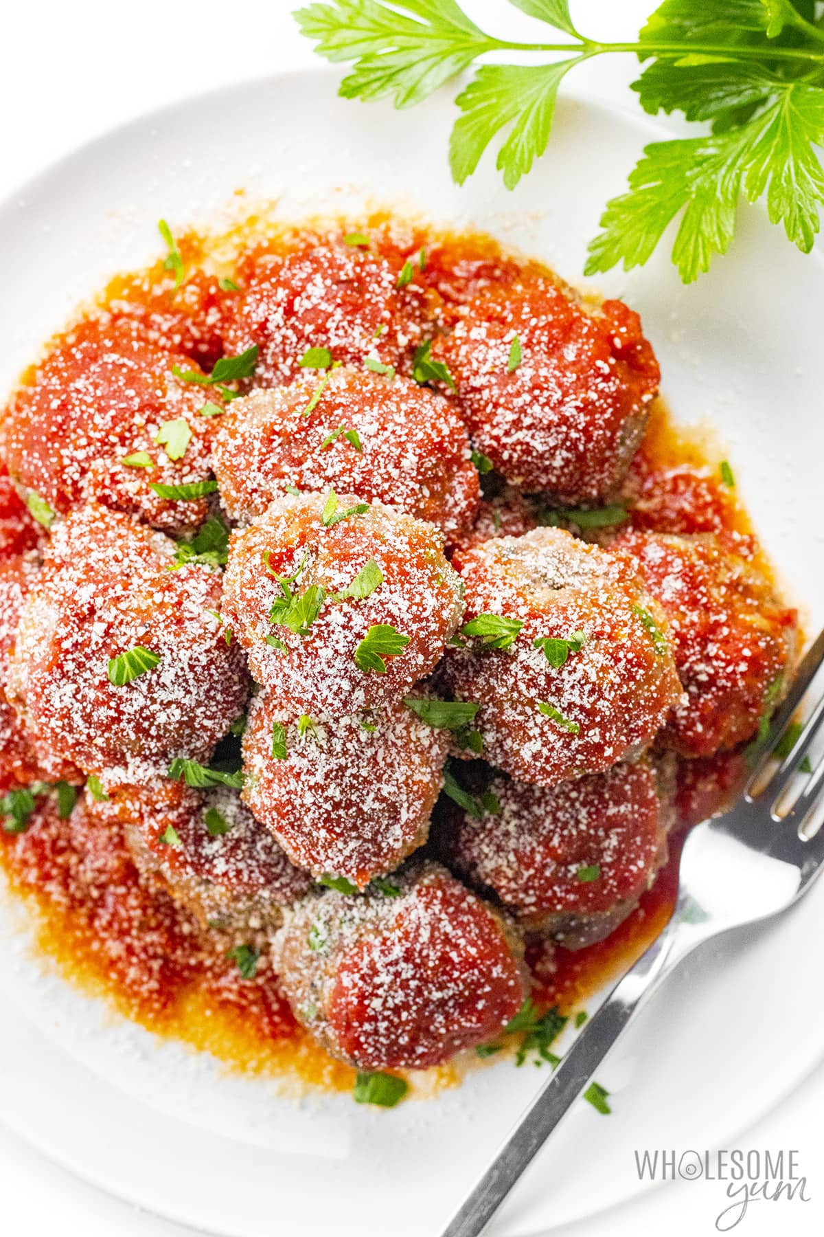 Oven baked low carb meatballs on a plate with a fork.