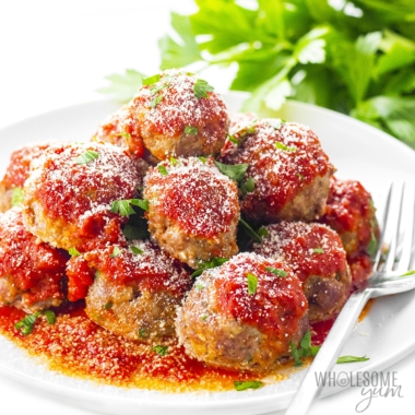 Low carb meatballs piled high on a plate with a fork.